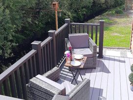 An outdoor seating area with chairs and a table at Min yr Afon Cabin Sleeps2 Hot Tub Parking in Gwalchmai