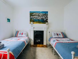 A bedroom with two beds and a fireplace at The Slipway Fowey Harbour with Garden in Fowey