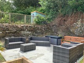 A garden with outdoor furniture and a rock wall at The Slipway Fowey Harbour with Garden Fowey