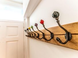 Coat rack with colorful hooks in a hallway at The Slipway Fowey Harbour with Garden Fowey