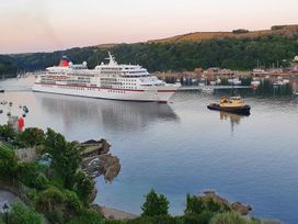 A cruise ship with a tugboat on water at The Slipway Fowey Harbour with Garden Fowey