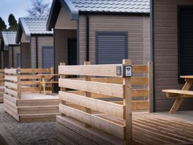 A wooden fenced area with cabins and seating at Selfcatering Lodge Inverness Sleeps 4 Inverness