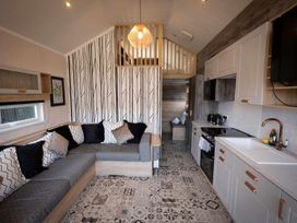A living room with a sofa and kitchen unit at Selfcatering Lodge Inverness Sleeps 4 Inverness
