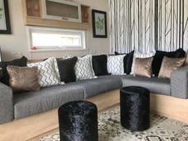 A living room with a sofa and pillows at Selfcatering Lodge Inverness Sleeps 4 in Inverness