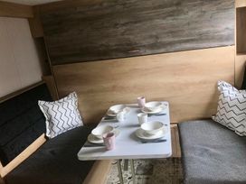 A dining area with a table and seating at Selfcatering Lodge Inverness  Sleeps 4 Inverness