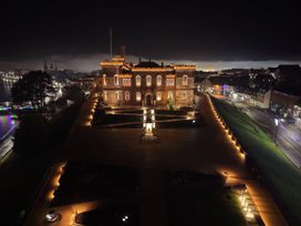 A historic building illuminated at night with a Christmas tree and pathways at Selfcatering Lodge Inverness Sleeps 4 Inverness