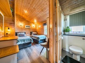 A bedroom with two beds and a bathroom area at Alpaca Farm Valley Views Sleeps 4 Parking Pets in Husthwaite