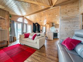 A living room with a sofa and kitchen area at Alpaca Farm Valley Views Sleeps 4 Parking Pets Husthwaite