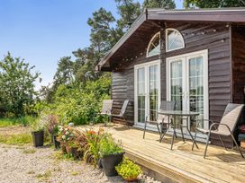 A cabin balcony with chairs and table at Alpaca Farm Valley Views Sleeps 4 Parking Pets Husthwaite