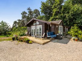 A cottage with a deck and chairs at Alpaca Farm Valley Views Sleeps 4 Parking Pets Husthwaite