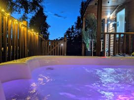 An outdoor area with a hot tub and patio lights at Felmoor Park Northumberland Lodge with Hot Tub Felmoor Park near Felton
