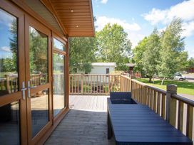 An outdoor deck with a table and chairs at Felmoor Park Northumberland Lodge with Hot Tub Felmoor Park near Felton