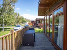 An outdoor area with a table and chairs at Felmoor Park Northumberland Lodge with Hot Tub near Felton