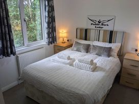 A bedroom with a bed and bedside tables at Puddle Duck Lodge Felmoor Park near Felton