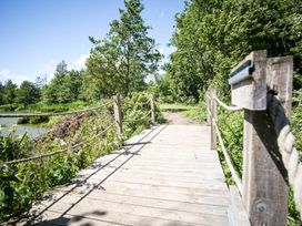 A wooden bridge with rope railing near water at Felmoor Park near Felton