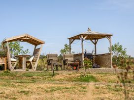 An outdoor area with a gazebo and seating at Cosy Luxury Owls Roost Hut with Private Hot Tub Little Deptford Farm near Umberleigh