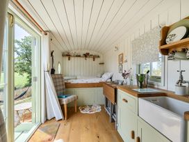 A studio with a bed and kitchen area at Cosy Luxury Owls Roost Hut with Private Hot Tub near Little Deptford Farm