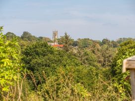 A view of a church tower among trees at Cosy Luxury Owls Roost Hut with Private Hot Tub Little Deptford Farm near Umberleigh
