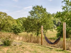 A hammock between wooden posts in a field at Cosy Luxury Owls Roost Hut with Private Hot Tub, Little Deptford Farm near Umberleigh