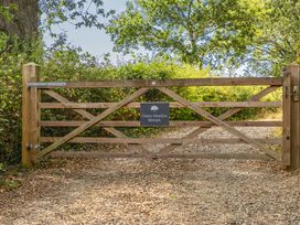 A wooden gate with a sign at Cherry Meadow Retreats near a gravel path