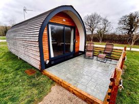A pod cabin with a deck and chairs at 1Bed pod cabin in beautiful surroundings Wrexham
