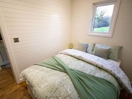 A bedroom with a bed and a window at 1Bed pod cabin in beautiful surroundings Wrexham