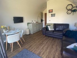 A living room with a sofa and dining area at 1Bed pod cabin in beautiful surroundings Wrexham