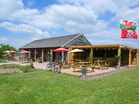 An outdoor seating area with tables and flags at 1Bed pod cabin in beautiful surroundings Wrexham