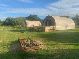Wooden cabins and a flower garden in outdoor surroundings at 1Bed pod cabin in beautiful surroundings Wrexham