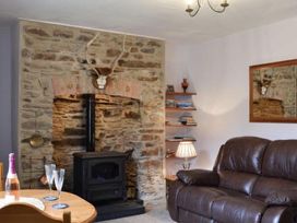 A living room with a stove and dining table at The Old Barn in Manchester