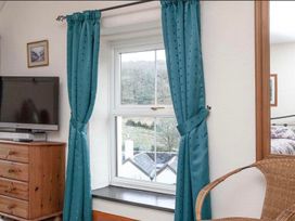 A bedroom with a window, television, and chest of drawers at The Old Barn in Manchester