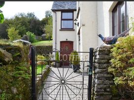 A cottage entrance with a gate and pathway at Rose Cottage