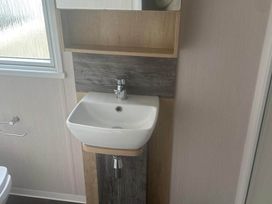 A sink with a faucet and mirror in the bathroom at Charming Caravan in beautiful Seton Sands, Cockenzie And Port Seton