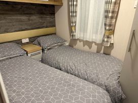 A bedroom with two single beds and a window at Charming Caravan in beautiful Seton Sands Cockenzie And Port Seton
