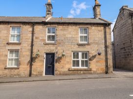 A stone building with a door and windows at Cooper's Cottage in Morpeth