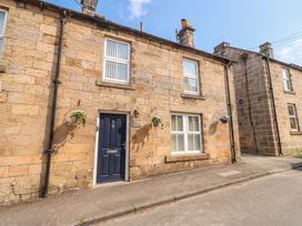A stone exterior of a house with door and windows at Cooper's Cottage in Morpeth