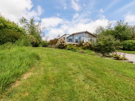 A garden with grass and an outdoor structure at 4 Tree Tops Liskeard