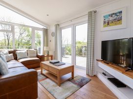 A living room with a sofa, coffee table and television at 4 Tree Tops Liskeard