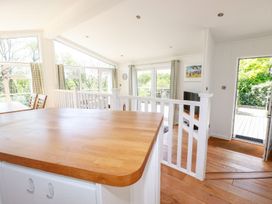 A kitchen with a wooden island and dining area at 4 Tree Tops in Liskeard