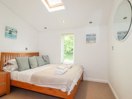 A bedroom with a bed and a window at 4 Tree Tops in Liskeard