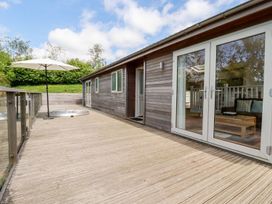 An outdoor area with a deck and a hot tub at 4 Tree Tops in Liskeard