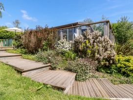 A garden with steps leading to an outdoor structure at 4 Tree Tops in Liskeard