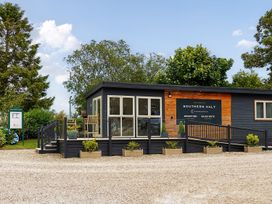 A reception building with sign and chairs at Southern Halt in Dobwalls