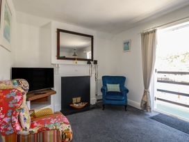 A living room with a television and chairs at Harbourside Retreat, Looe