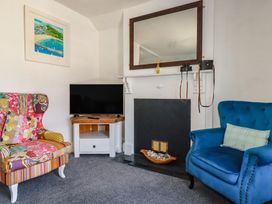 A living room with a fireplace and a television at Harbourside Retreat in Looe