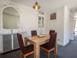 A dining room with a wooden table and four chairs at Harbourside Retreat in Looe