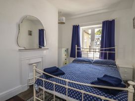 A bedroom with a bed and window at Harbourside Retreat in Looe