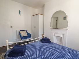 A bedroom with a bed and chair at Harbourside Retreat in Looe