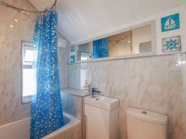 A bathroom with a bathtub, sink, and toilet at Harbourside Retreat in Looe
