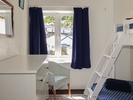 A bedroom with a bunk bed and a dresser at Harbourside Retreat in Looe